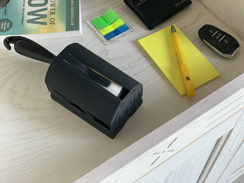 Black lint roller storage case on a tabletop with lint roller refills