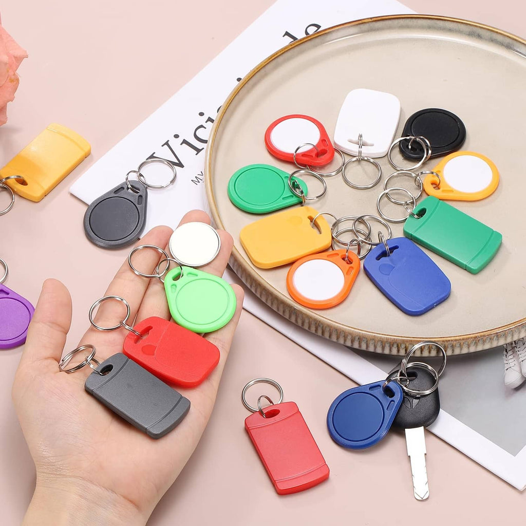 Assorted colored RFID key fobs with metal key rings on a tray