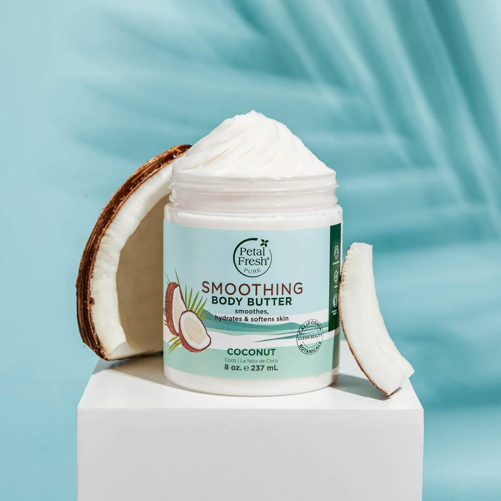 Coconut body butter jar with dollop on top and coconut halves beside it
