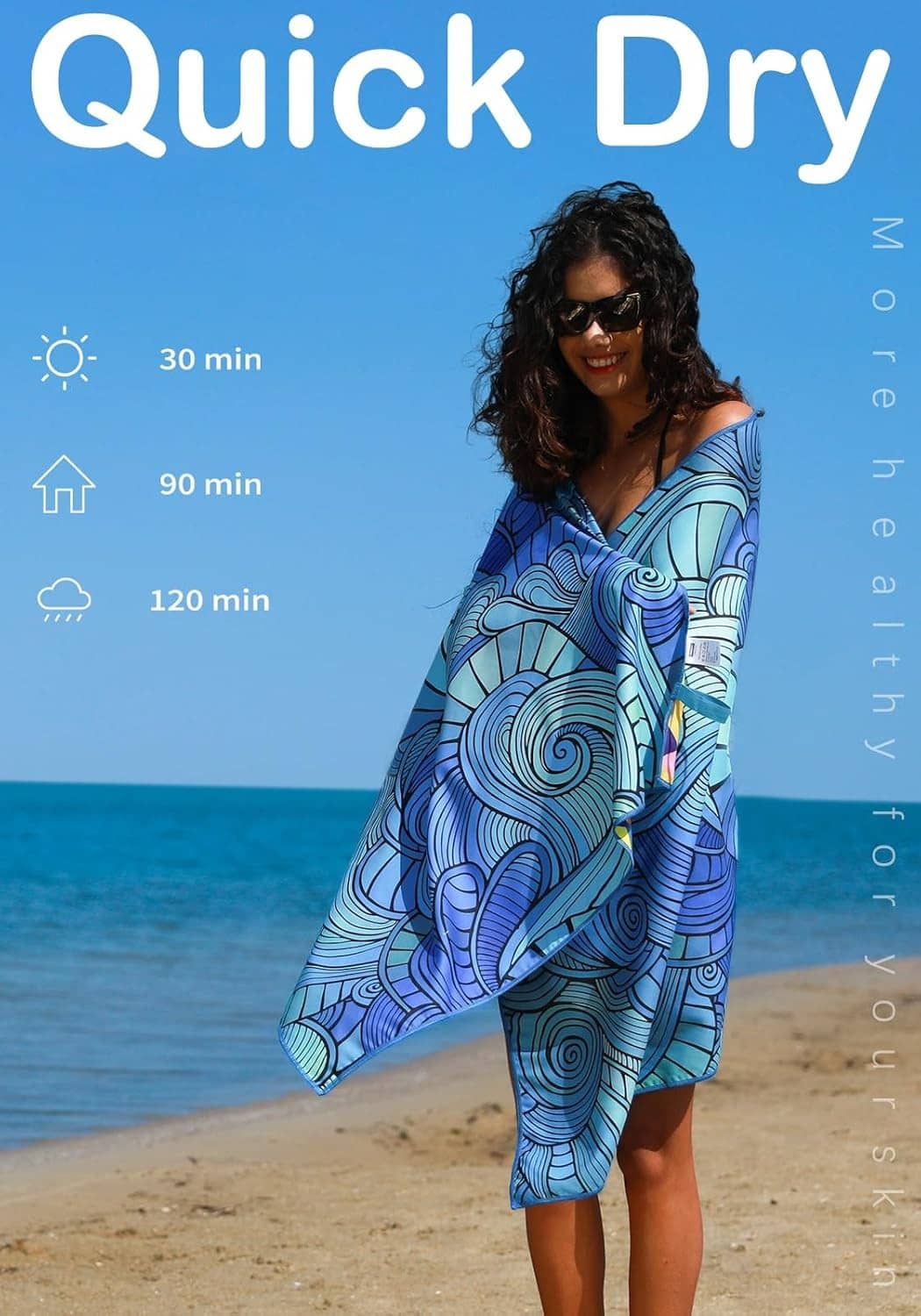 Blue swirl-pattern quick-dry style beach towel worn like a wrap on a beach
