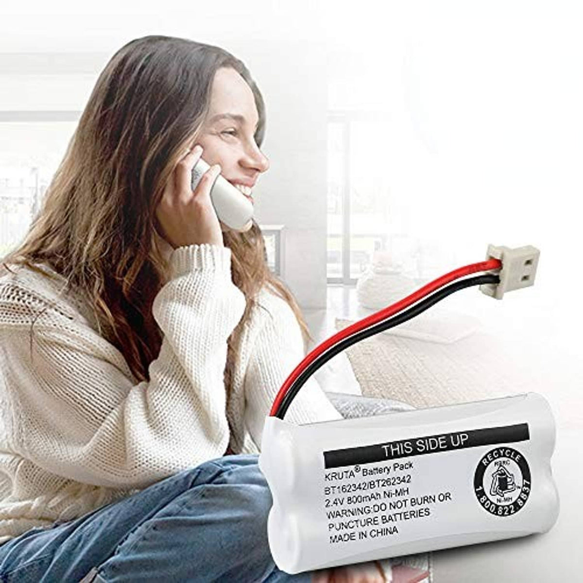 Cordless phone battery pack held by a person near a cordless phone handset