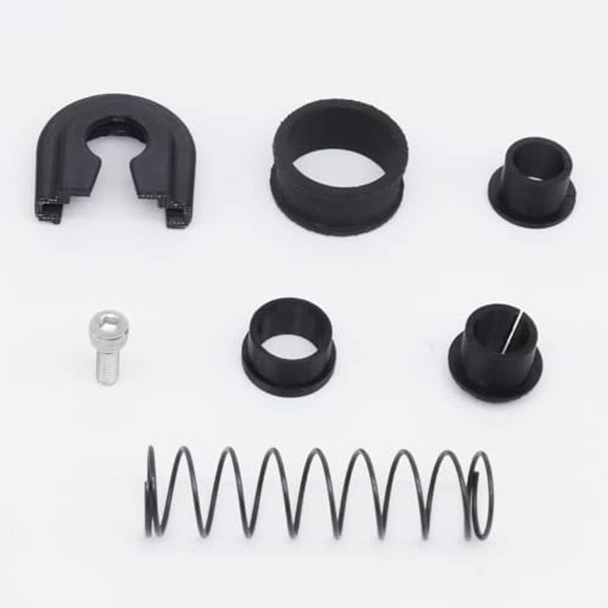 Gearbox repair kit components: several black rings, small bushings, spring and bolt