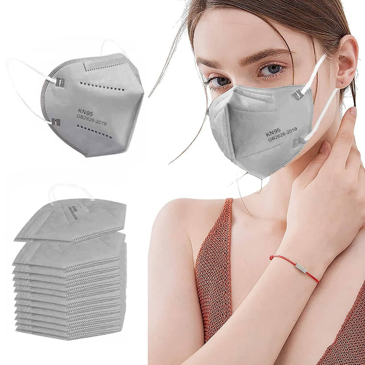 Grey KN95 face mask on a person with ear loops; plus stacked spare masks