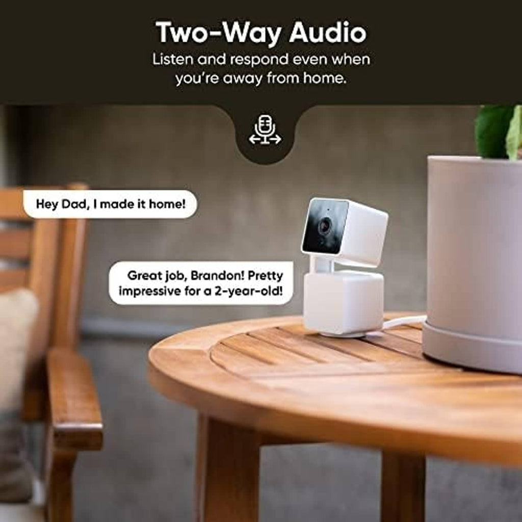 Wyze Cam Pan V3 white indoor security camera on wooden table with audio message bubbles
