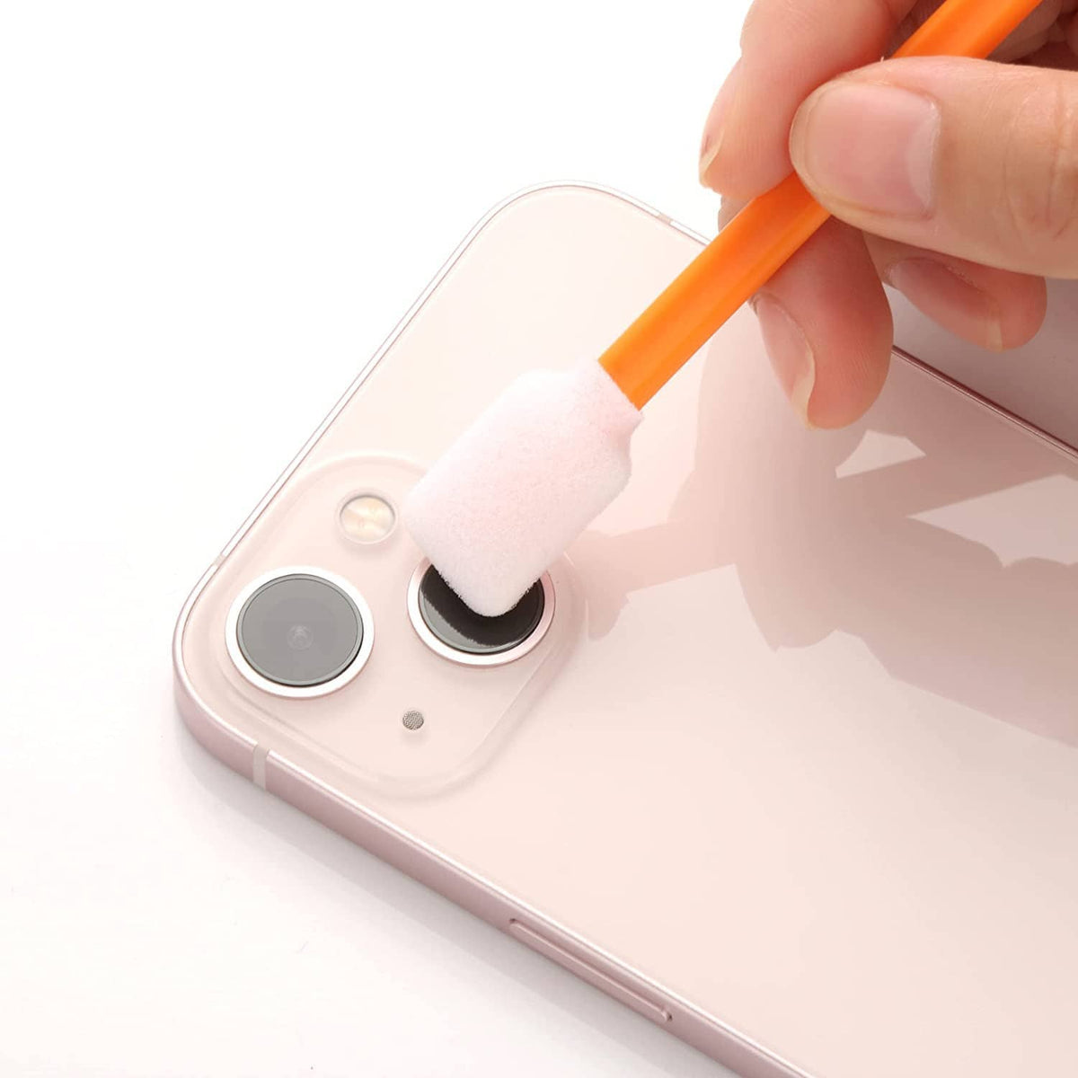 Orange foam swab with white tip cleaning a phone camera area.