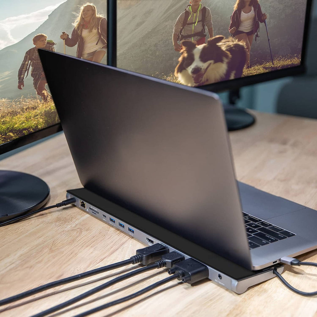 Black USB-C docking station connected to laptop with visible side ports and cables