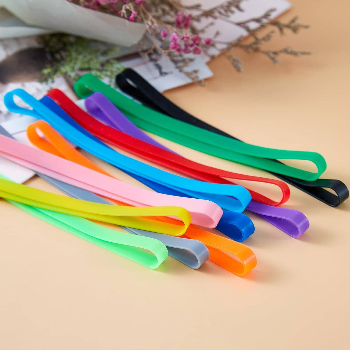 Assorted silicone elastic bands in bright colors, fanned out curved loops