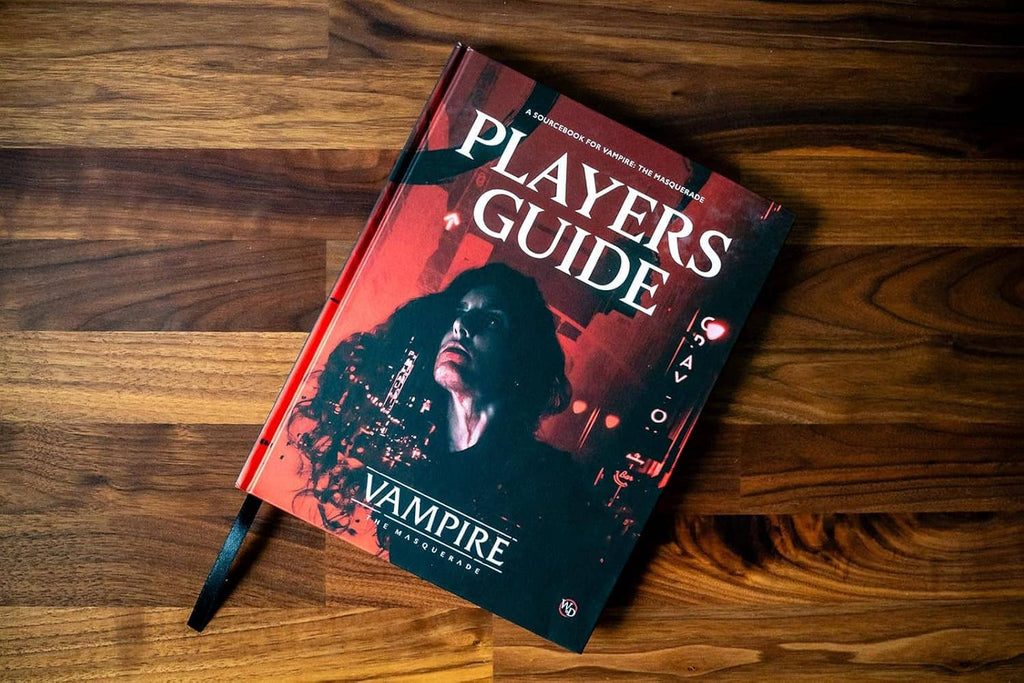Hardcover Players Guide book on wood surface, red-and-black cover with portrait