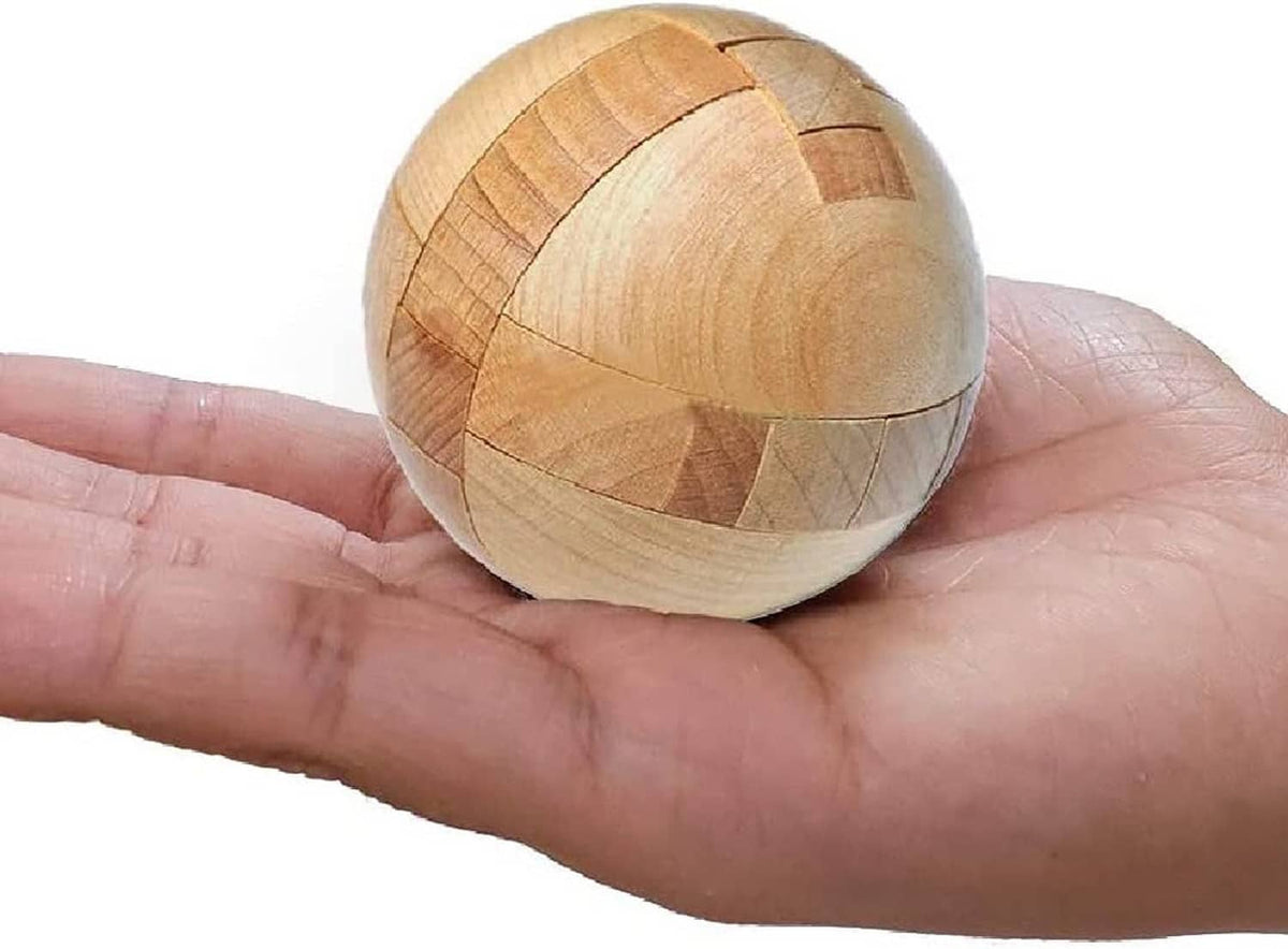 Wooden puzzle sphere resting on an open palm, showing interlocking segments