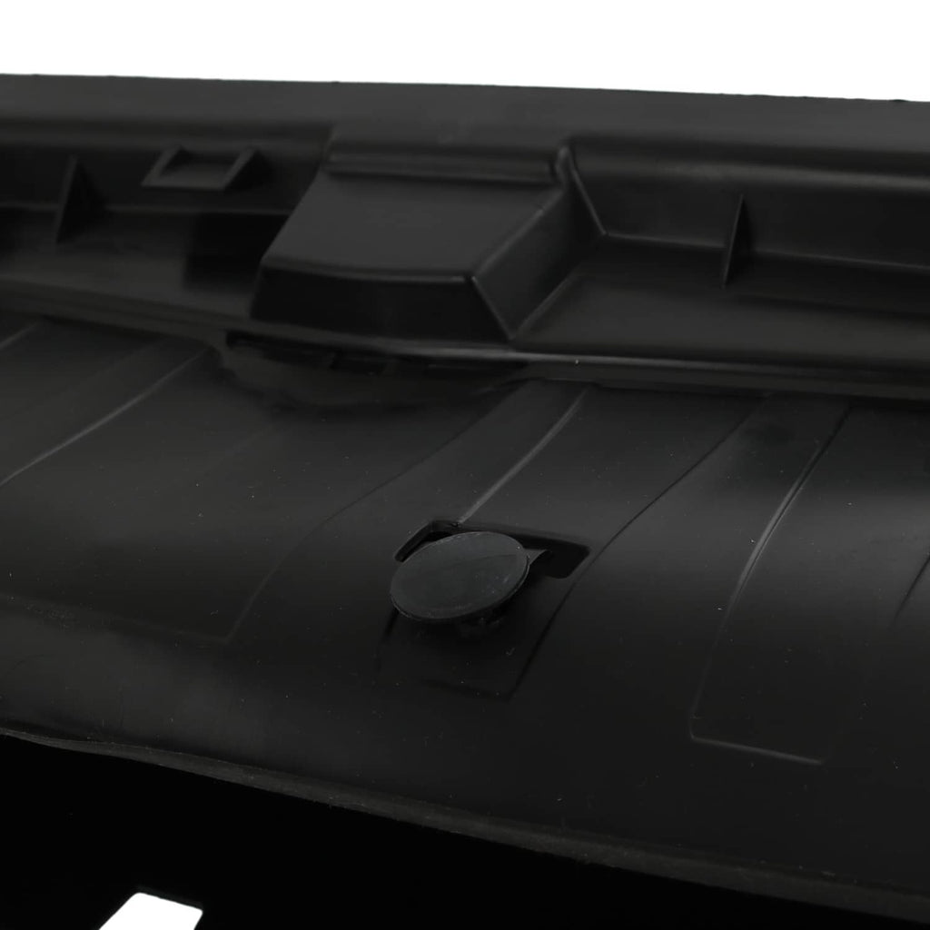 Close-up of black radiator shutter cover panel with small round access plug