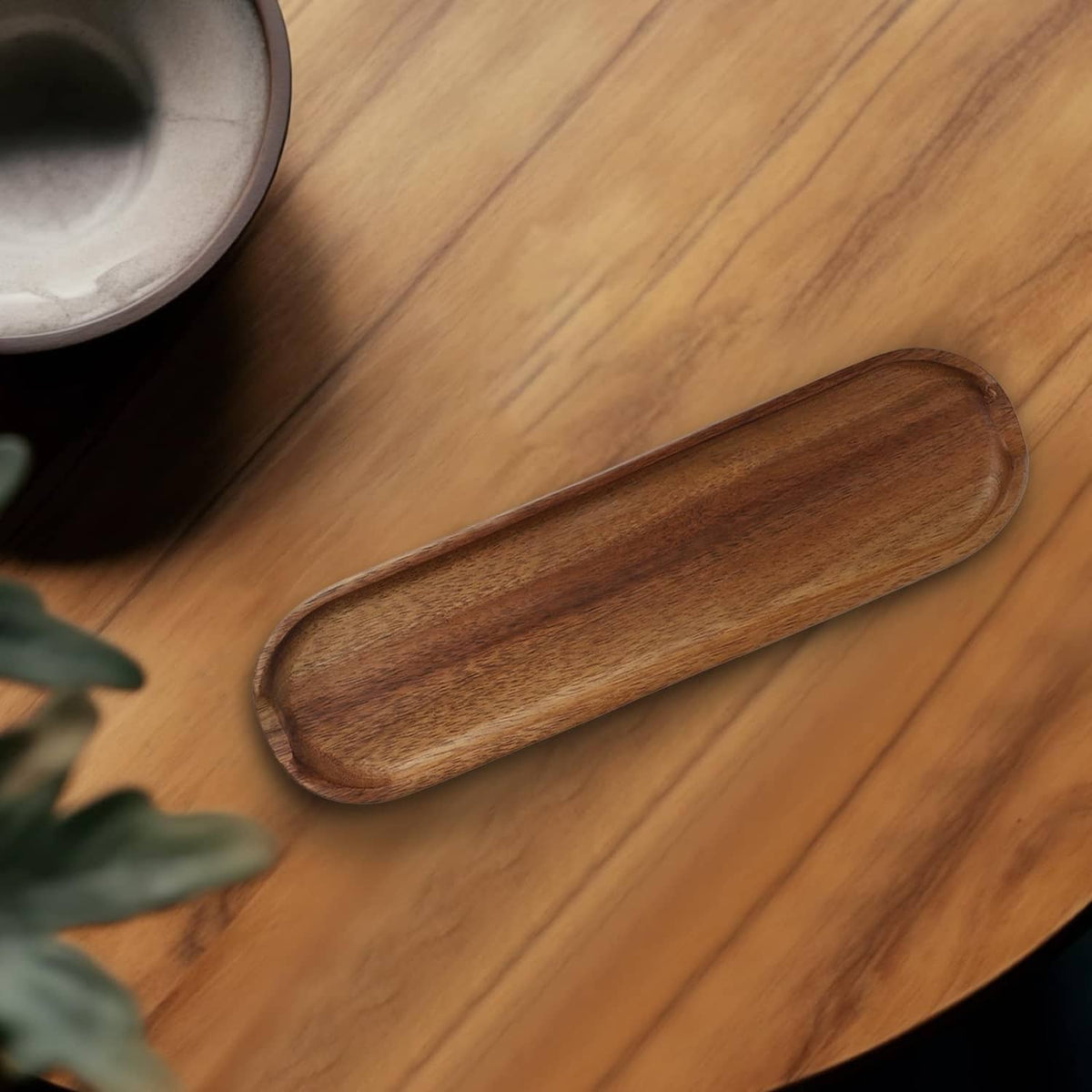 Brown wood pen tray, rounded oval shape close-up on desk surface