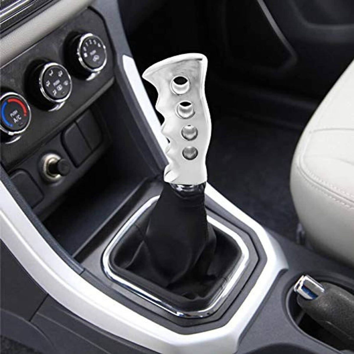 Silver gear shift knob installed in car with black shift boot and textured grip