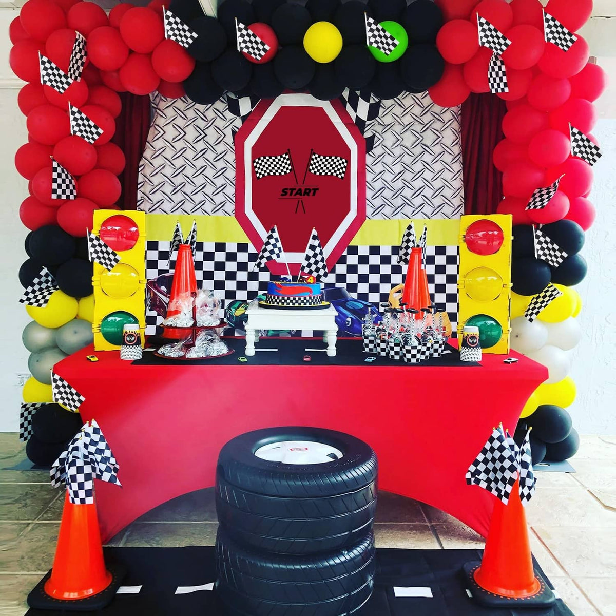 Black-and-white checkered race flags on sticks around a decorated party setup