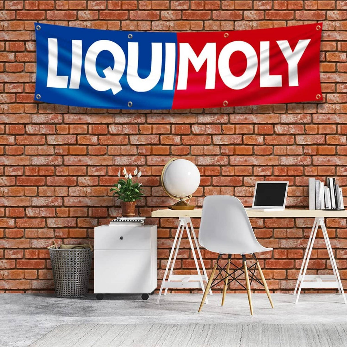 Liquid Moly blue and red banner flag with eyelets, shown hanging against a brick wall