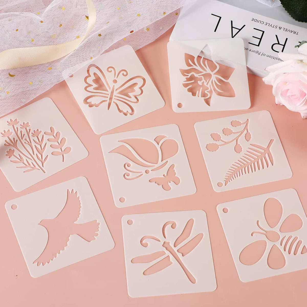Assorted stencil sheets with butterflies, birds, flowers, and leaves in white