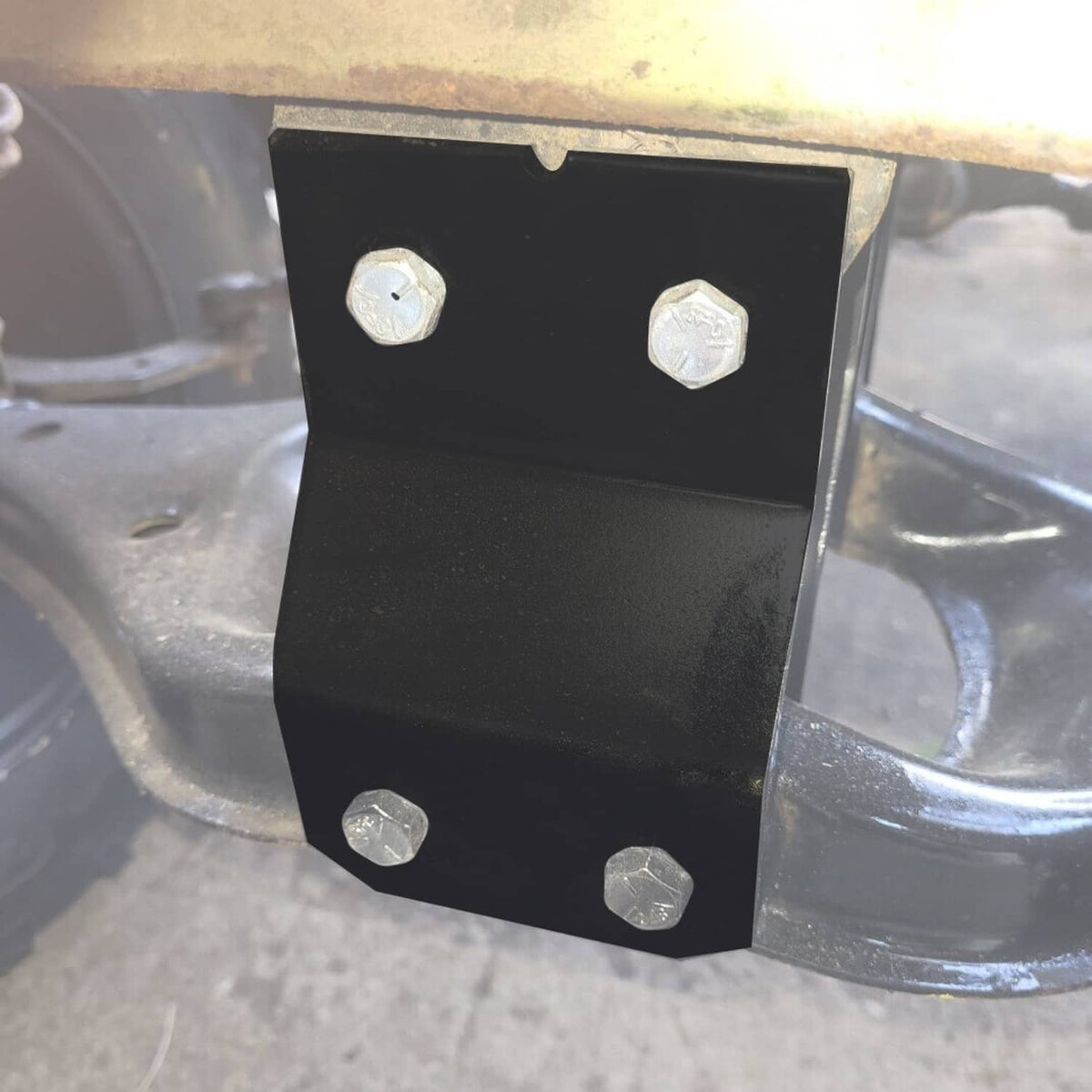 Black steel lift plate mounted to golf cart frame with bolts and washers