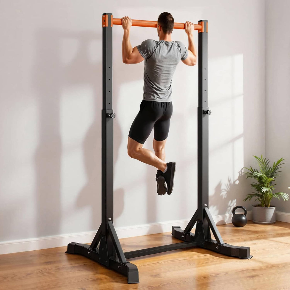 Freestanding pull up bar with orange crossbar and black uprights, shown performing pull-up