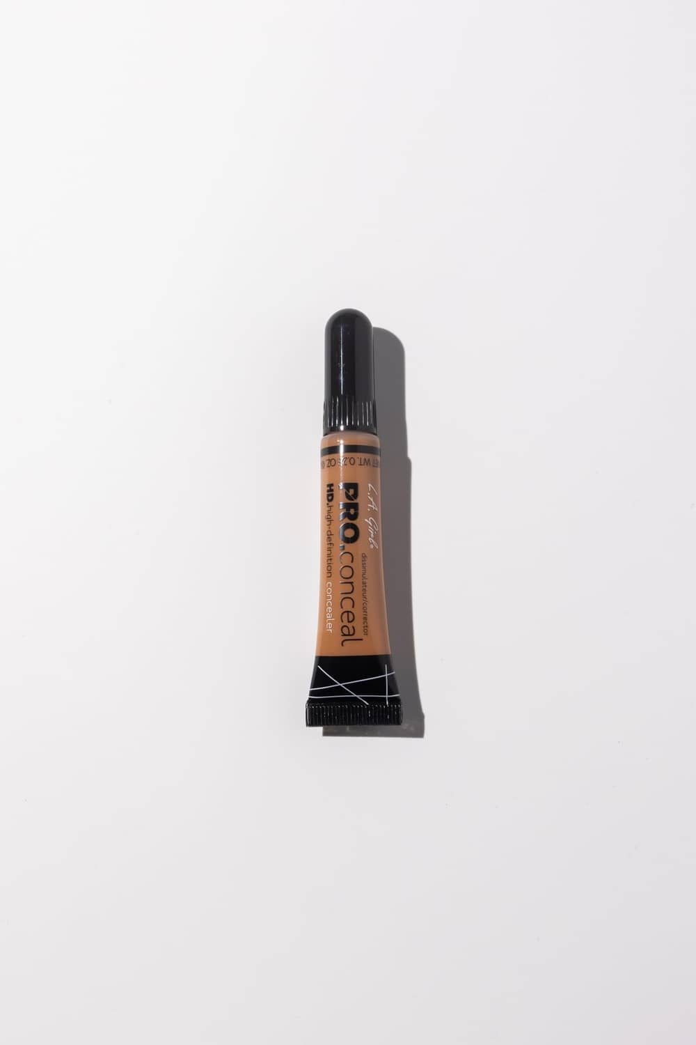 Cool tan concealer squeeze tube with capped applicator for targeted coverage