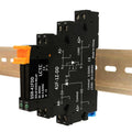 Black solid state relay on DIN rail with orange terminals and labeled A1-, A2+ wiring.