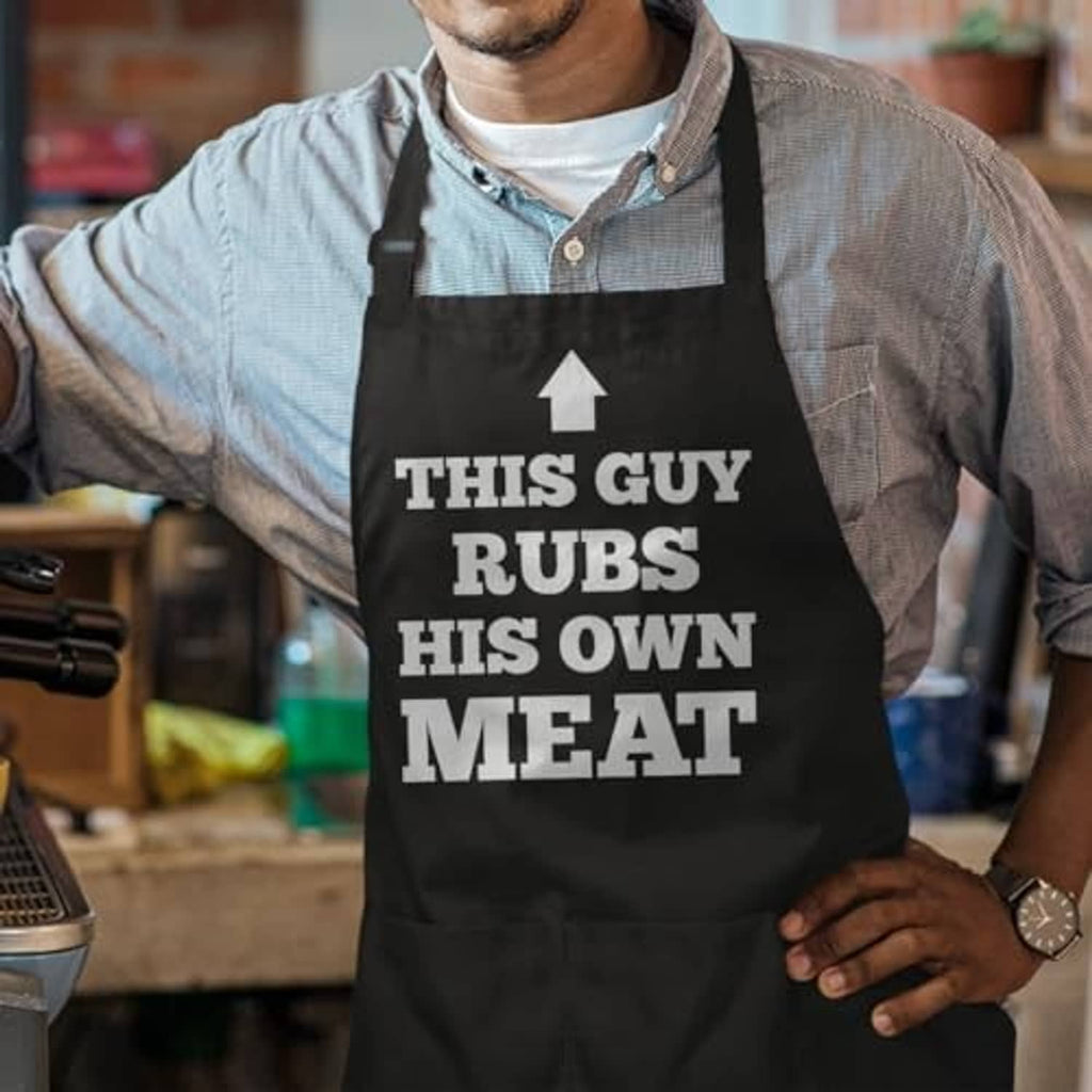 Black BBQ apron with 'THIS GUY RUBS HIS OWN MEAT' print, tool graphic, two pockets
