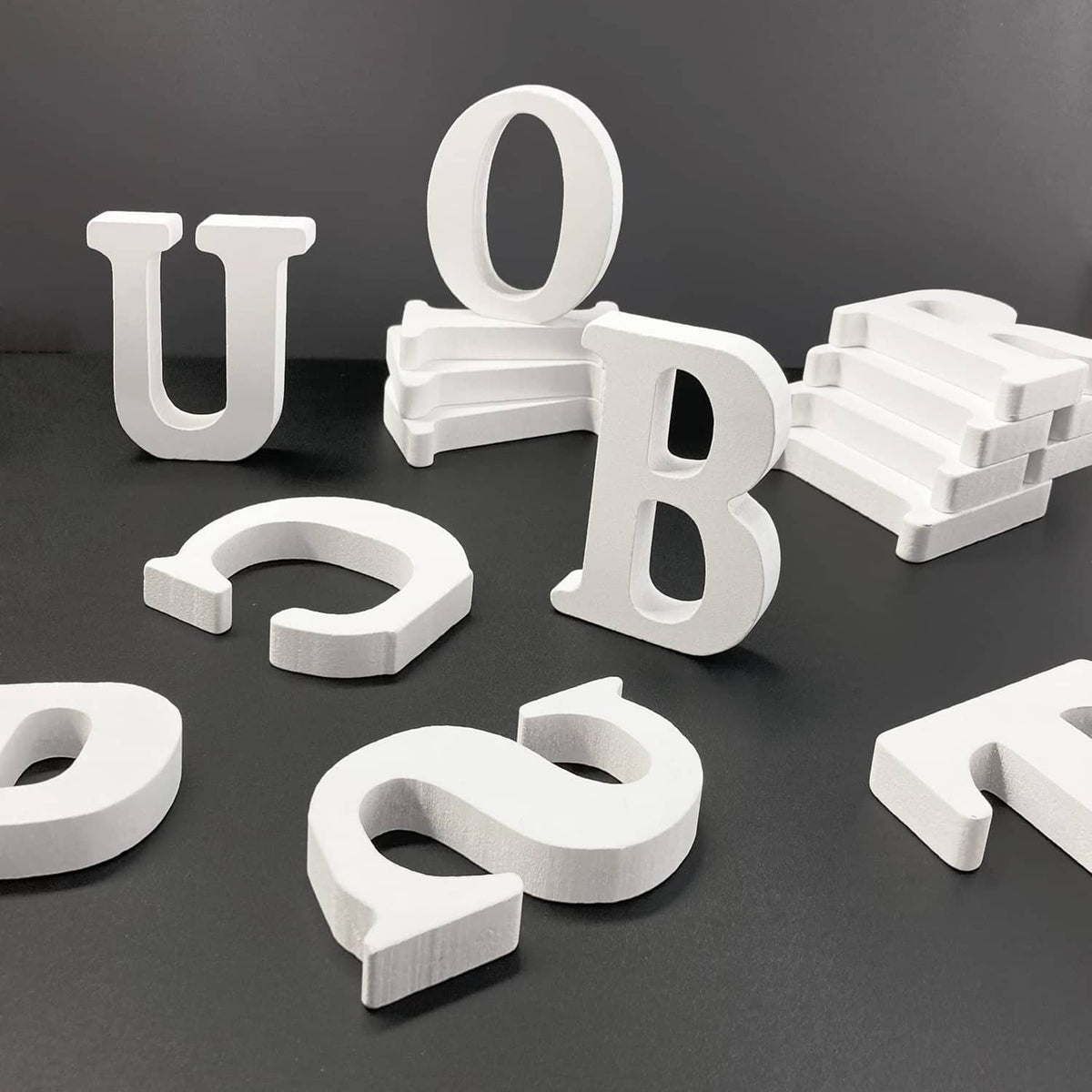 White unfinished wood marquee letters set with thick cutouts; letter O visible