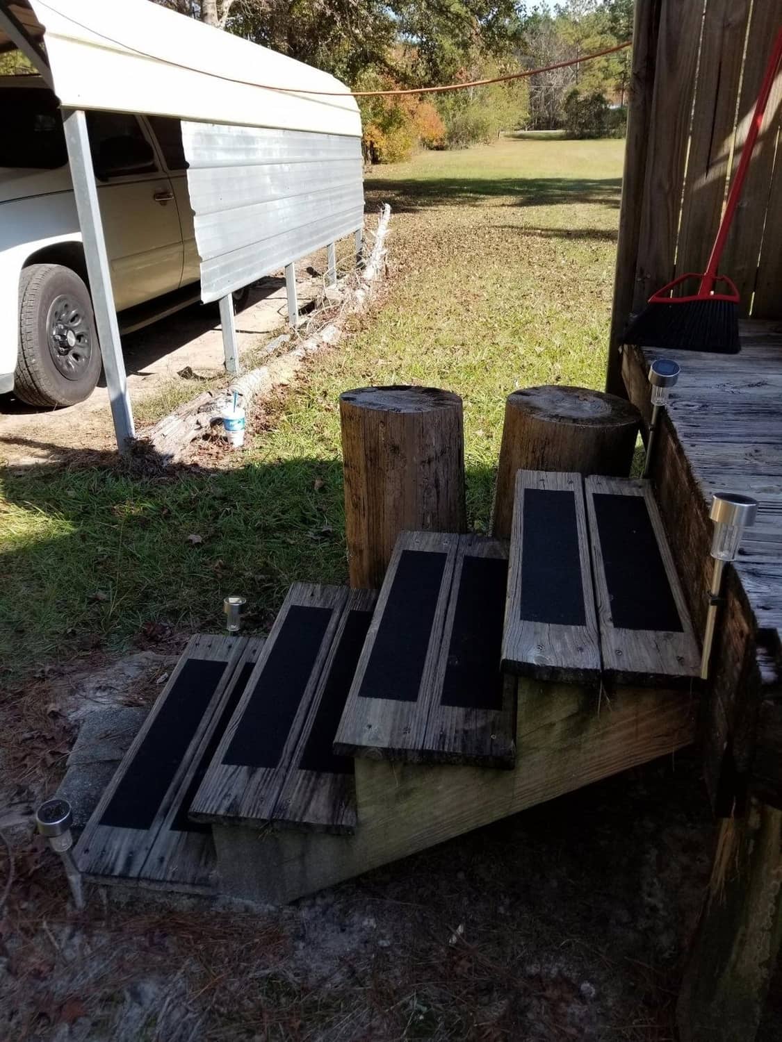 Anti-slip tape rectangles on wooden steps for traction, dark gray strips