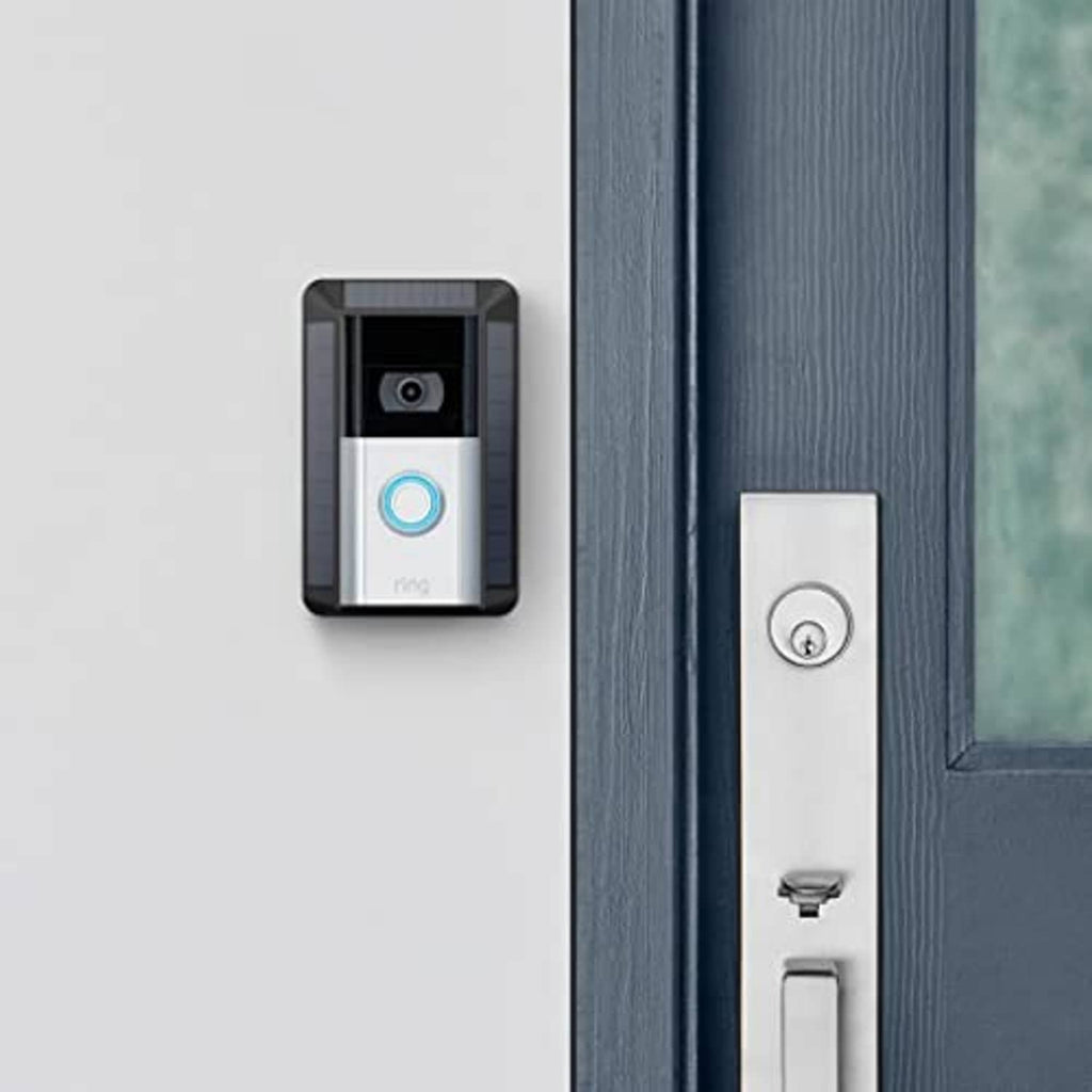 Solar-powered Ring doorbell charger mounted on wall next to a white doorbell button