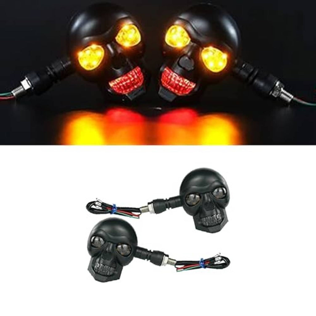 Two matte black skull motorcycle turn signals with amber lenses and red reflector sections