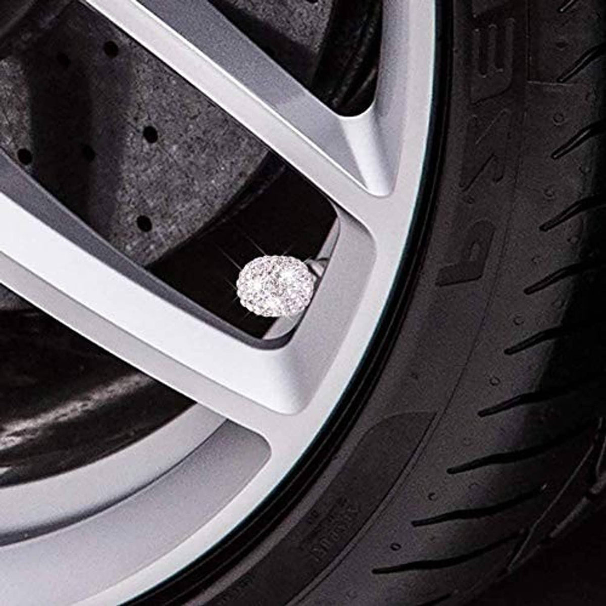 Crystal rhinestone valve stem cap on car wheel rim opening