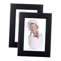 Set of 2 black wood picture frames, each holding a portrait photo with clear front