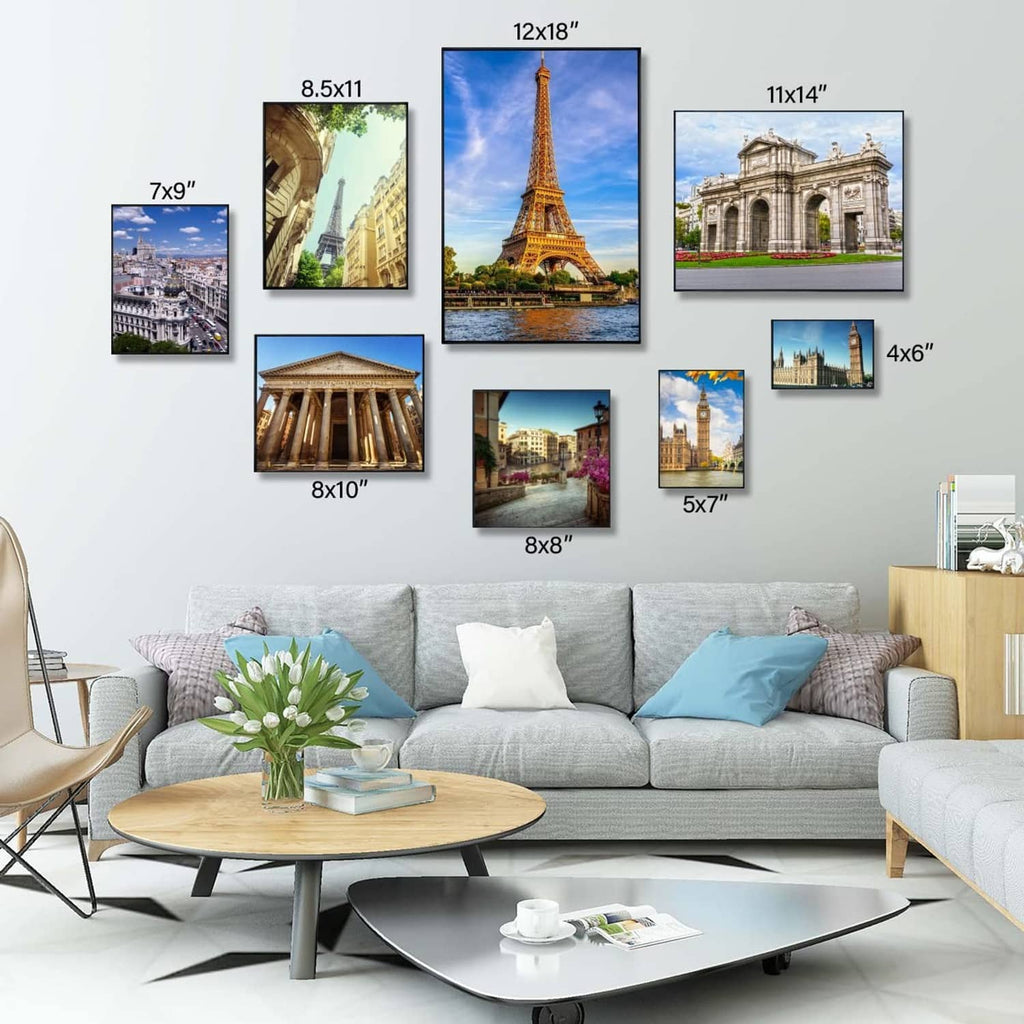 Black 4x6 photo frames grouped on a wall, assorted travel pictures inside