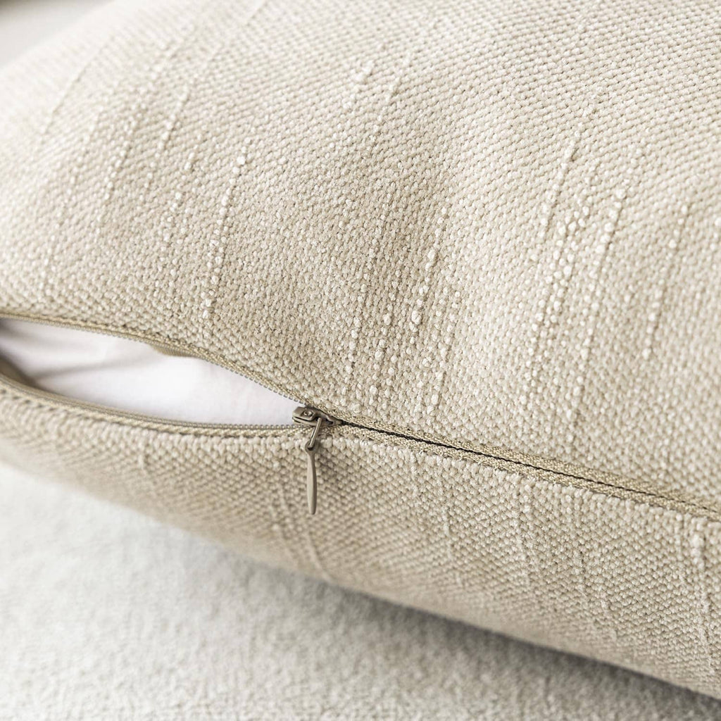 Light beige chenille throw pillow cover with hidden zipper along the edge seam.
