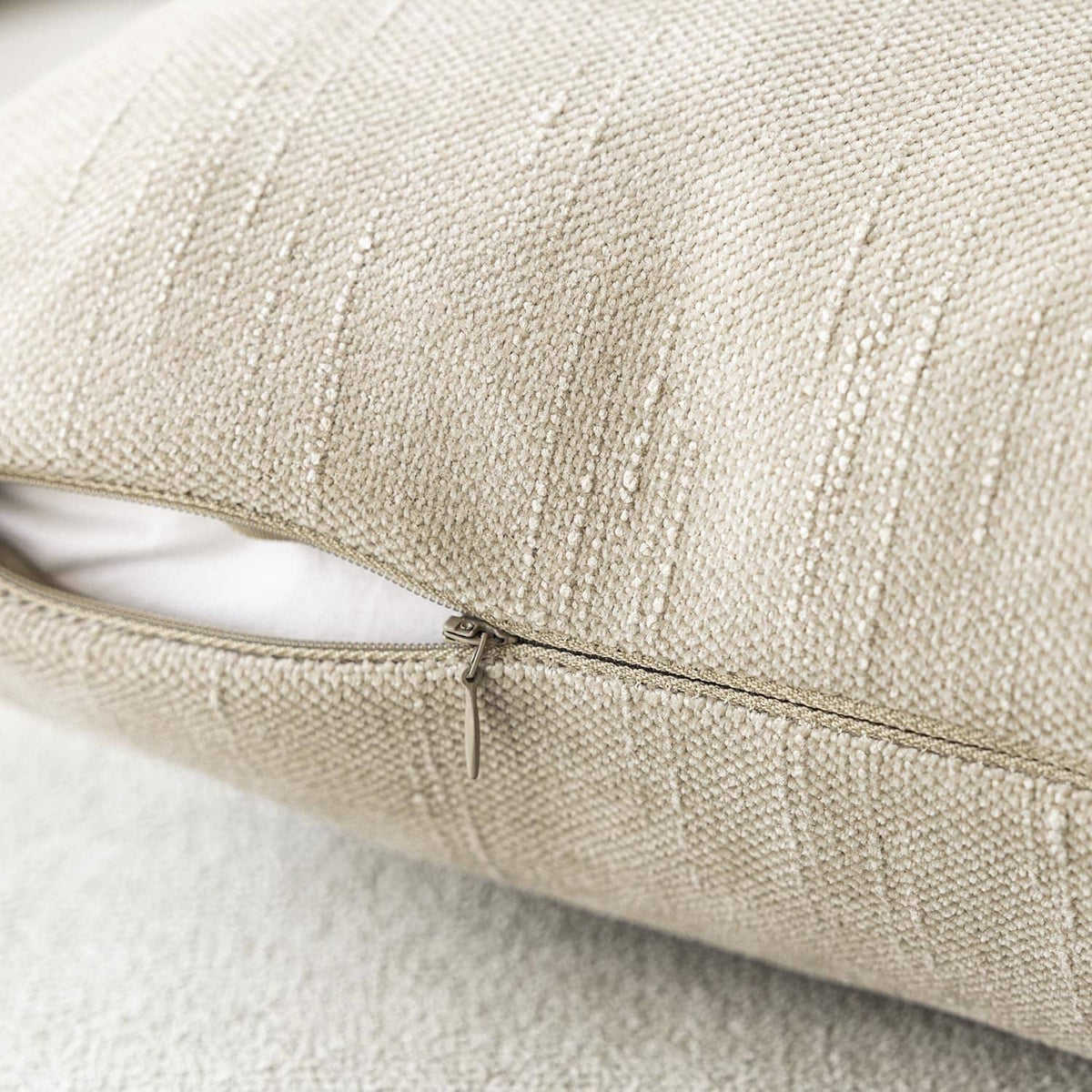 Light beige chenille throw pillow cover with hidden zipper along the edge seam.
