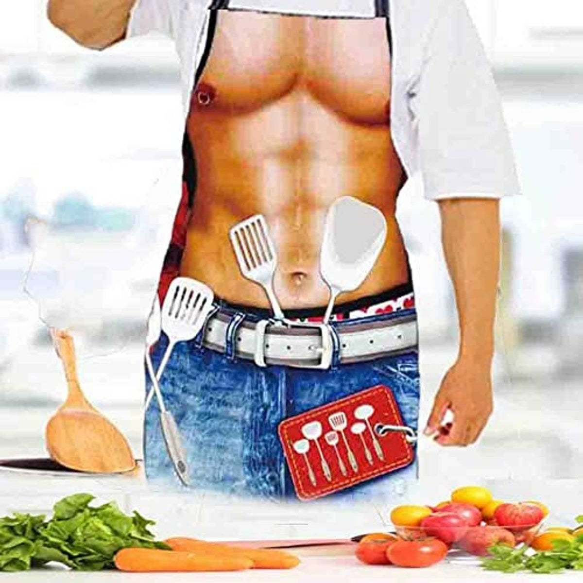 Cook wearing novelty bib apron with utensil icons on blue denim-style pocket