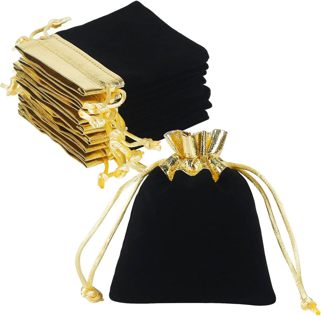 Stack of black velvet jewelry pouches with gold drawstring cords and tied pouch