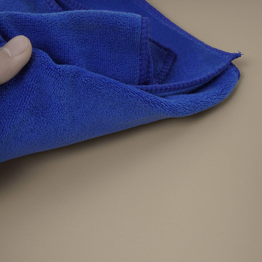 Beige seat cushion edge with blue cleaning cloth pressed along the surface