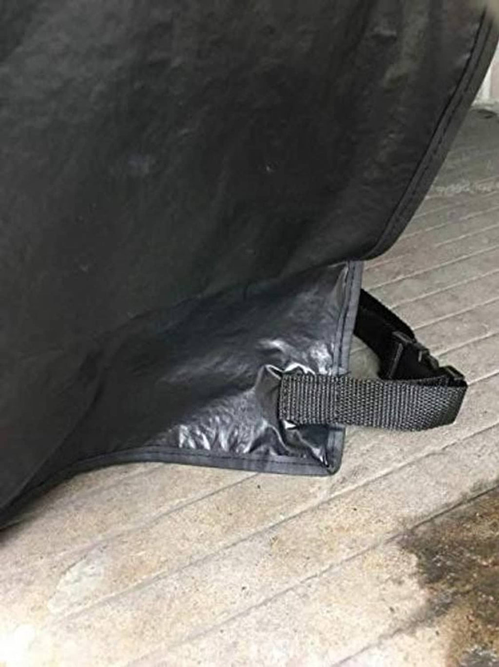 Black tire cover with reinforced strap and stitched seam near the bottom edge