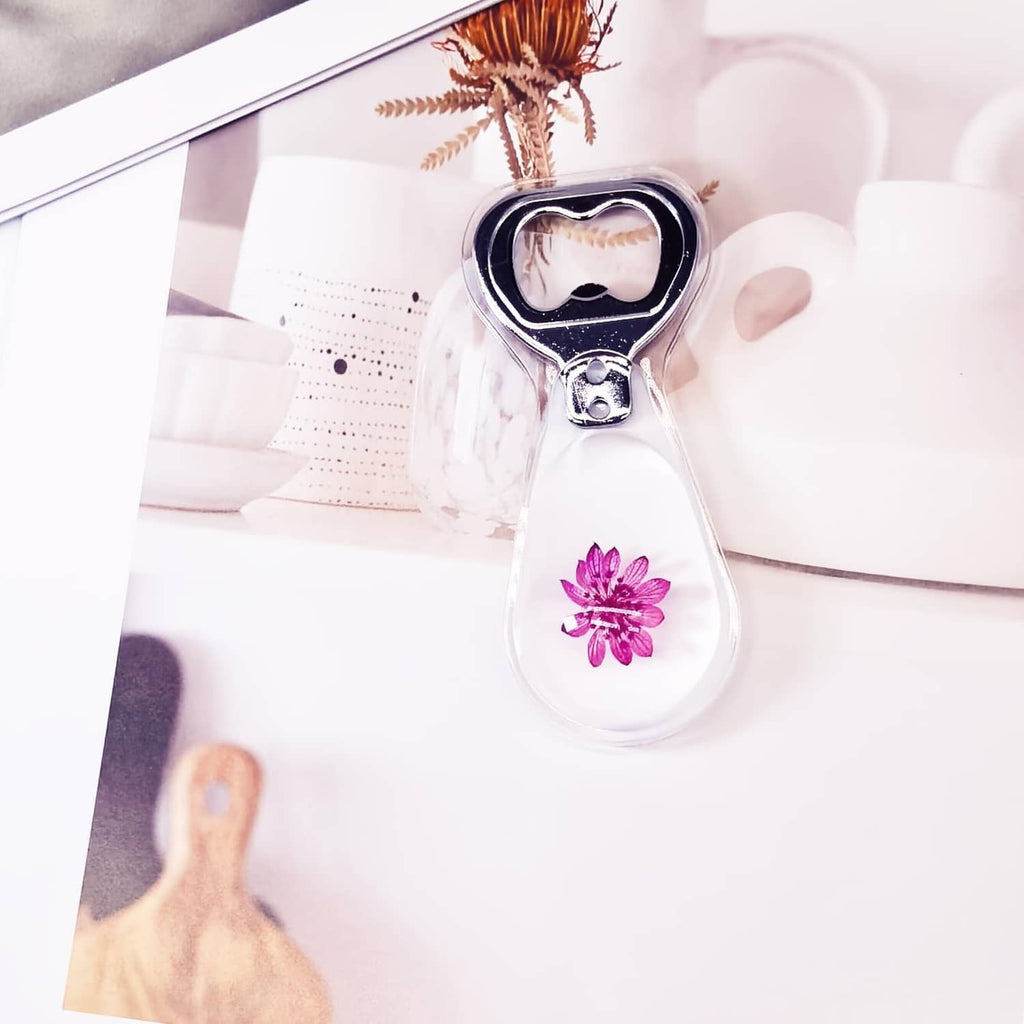 Resin bottle opener, clear drop shape with purple flower and black bottle cap