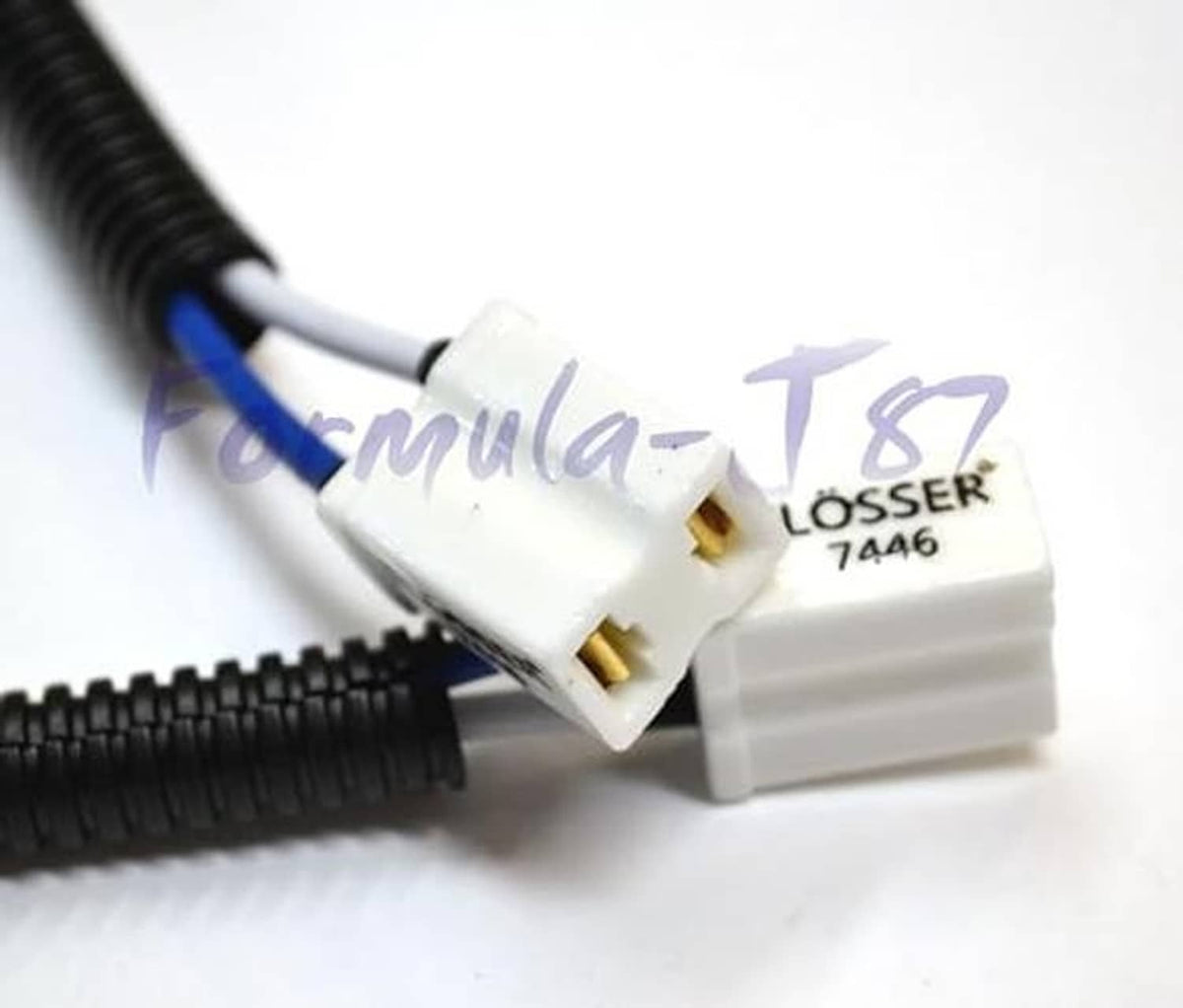 Close-up: white Flosser 7446 pigtail connector on black corrugated wire harness