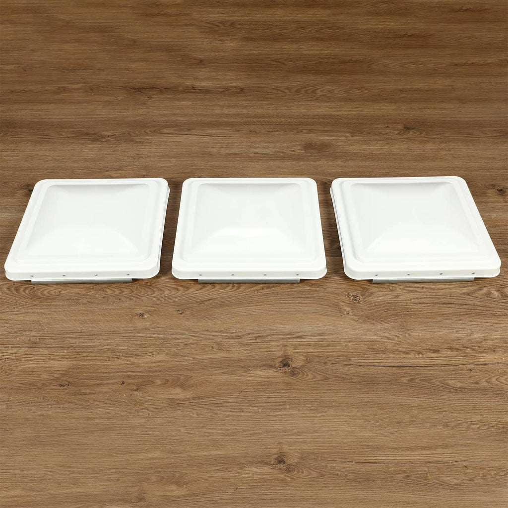 Three white RV roof vent cover lids lined up, square low-profile design