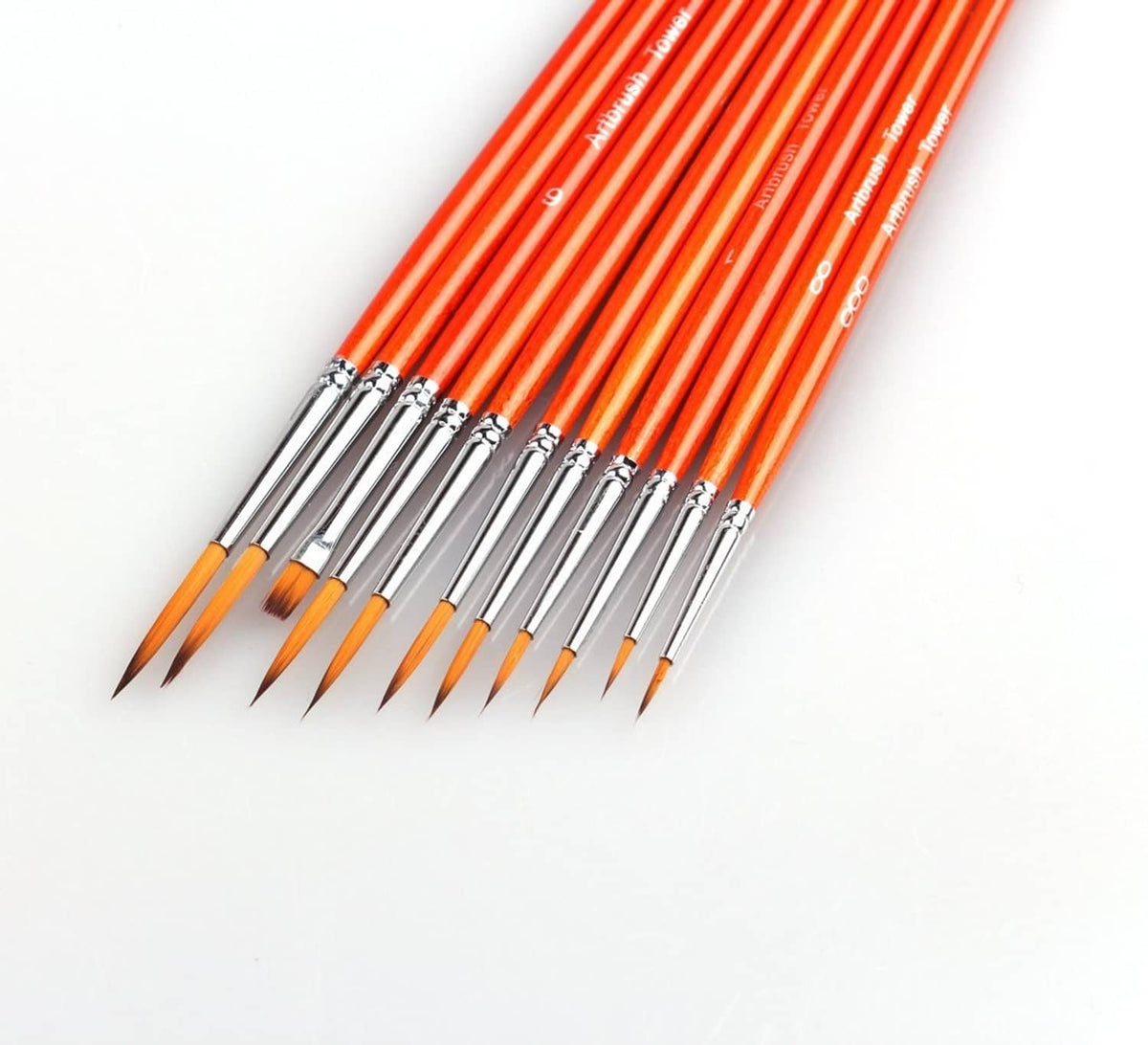 Close-up of orange-handled detail brushes with metal ferrules and pointed bristles