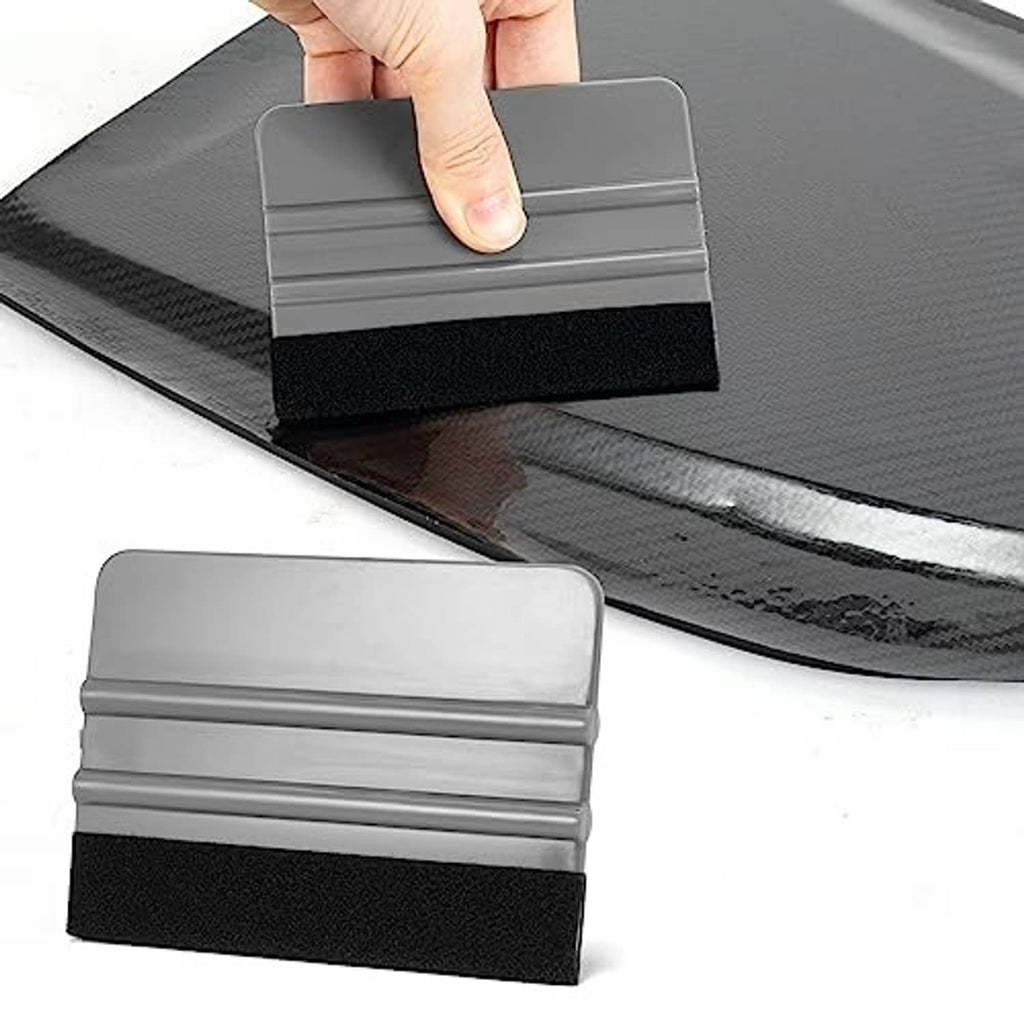 Hand pressing a gray felt squeegee with black felt edge onto vinyl sheet