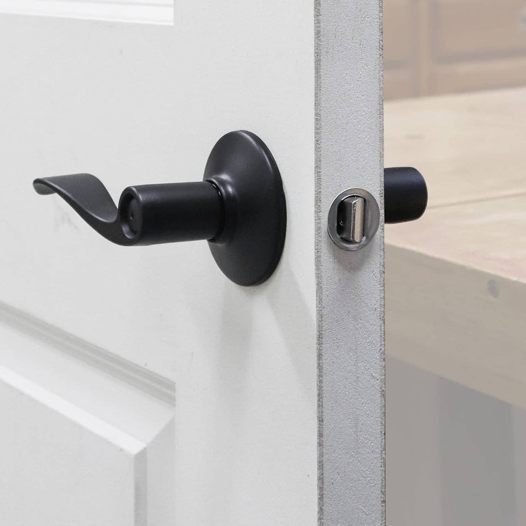 Black door lock handle and interior knob mounted on a drilled door panel