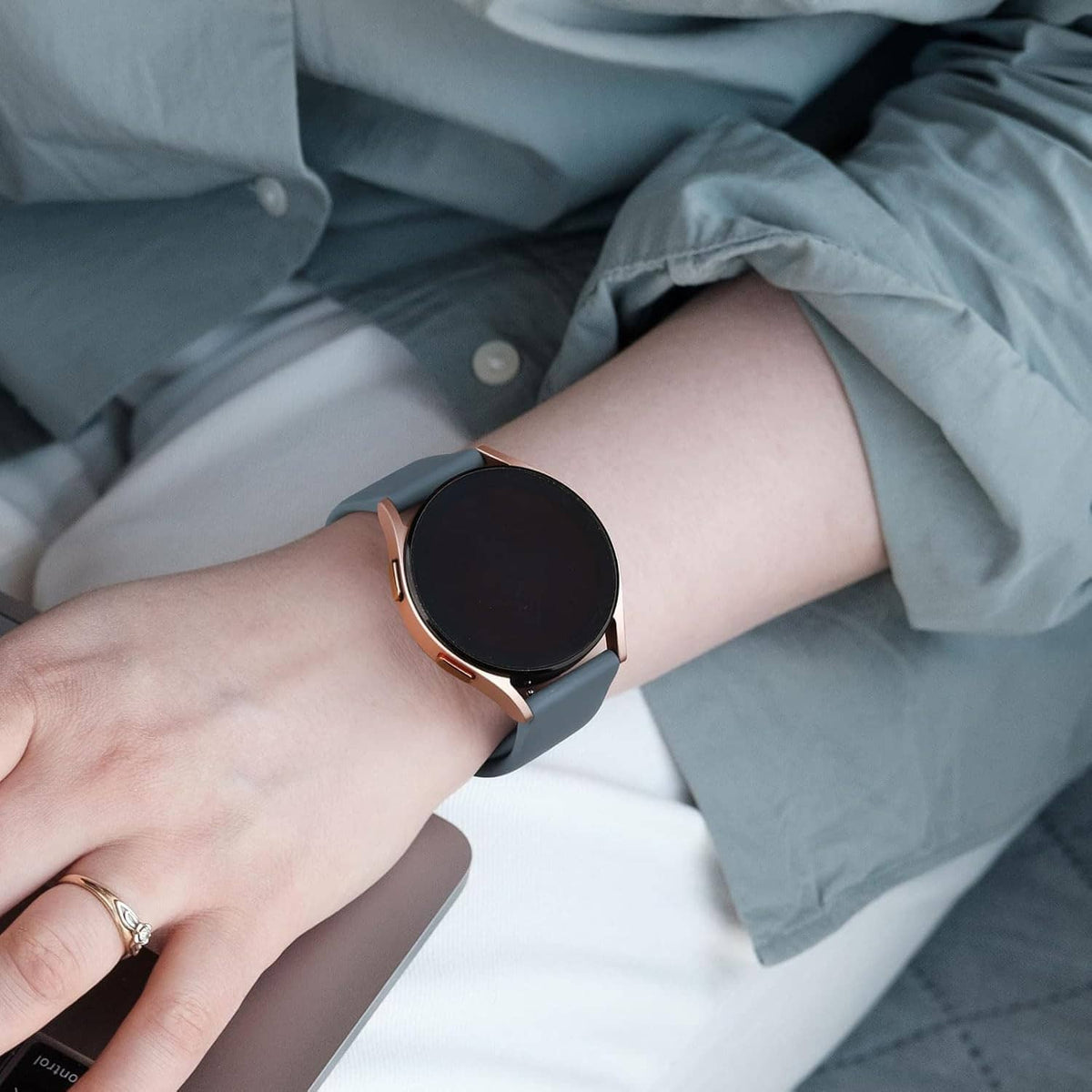 Black silicone watch band on smartwatch on wrist with rose-gold accents and quick-release