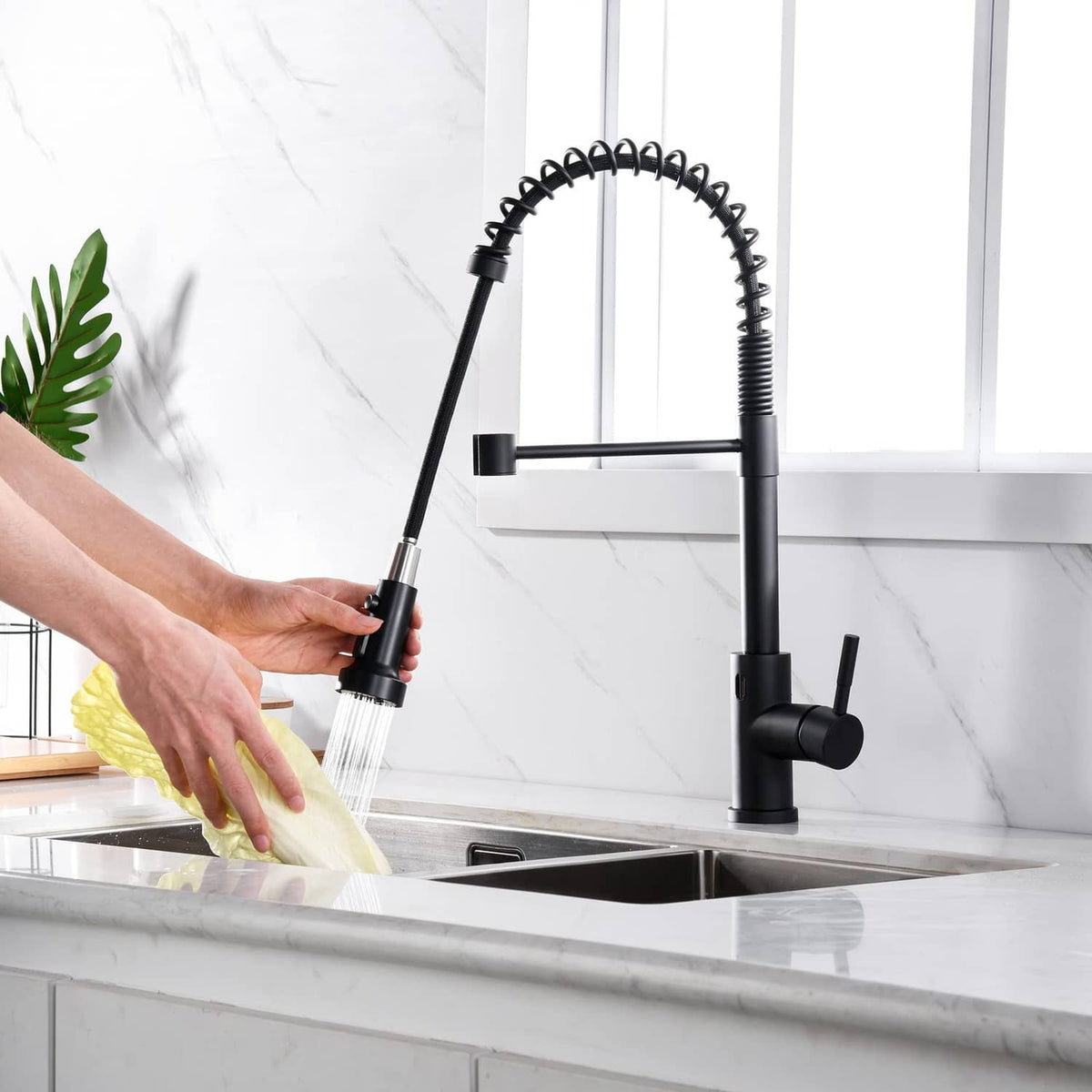 Matte black faucet head extension sprayer with water running over sink and hand-held hose