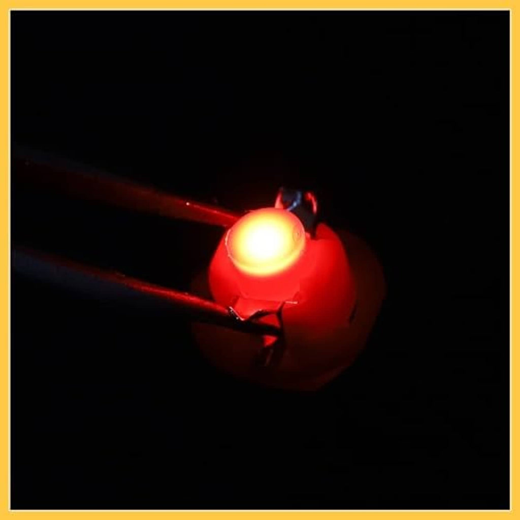 Red B8.4D LED bulb lit, showing bright warm red glow near the pin ends