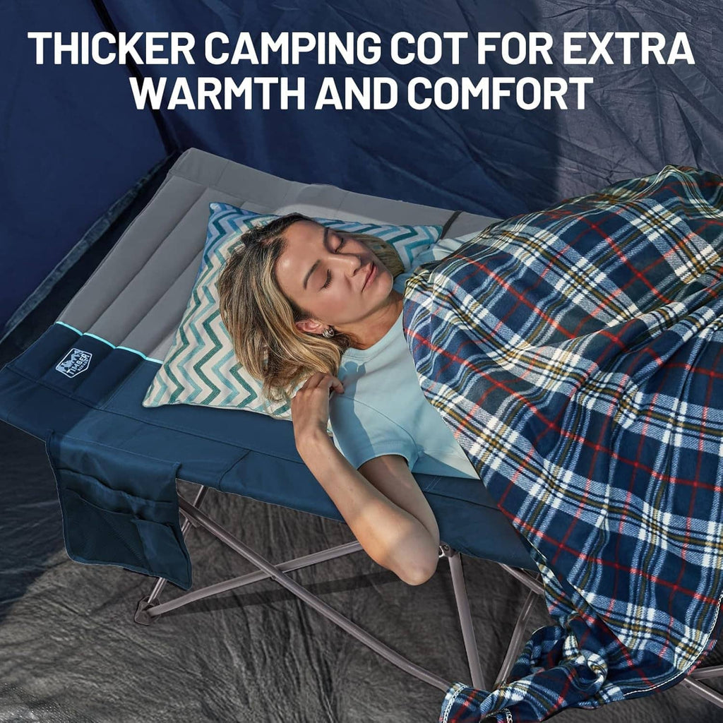 Camping cot with thick padded gray mattress and blue headrest for added comfort