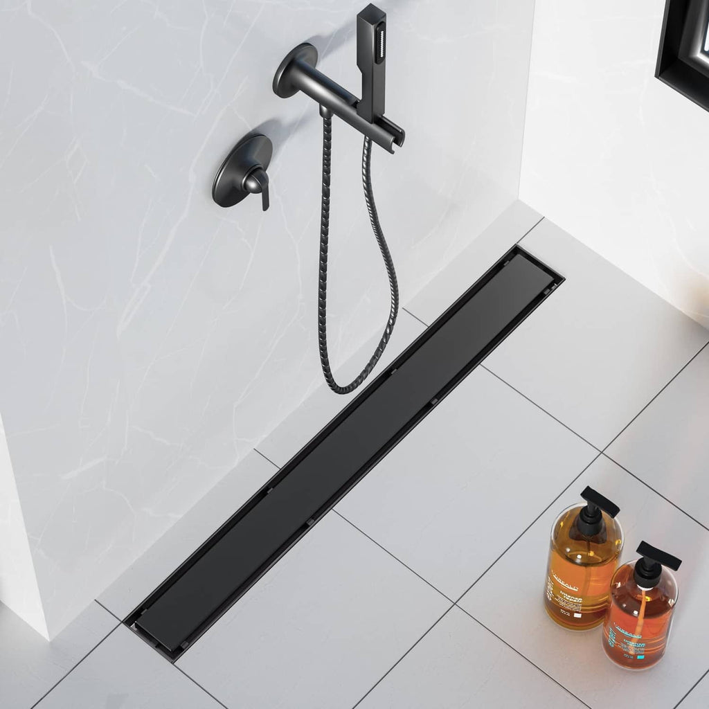 Matte black linear shower drain set into shower floor with rectangular cover