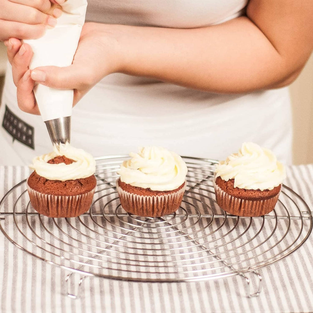 Tipless disposable piping bag piping frosting onto cupcakes on a cooling rack