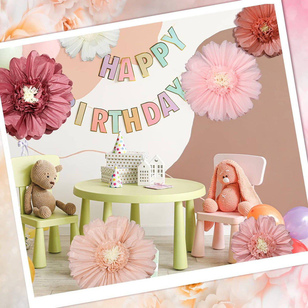 Birthday party backdrop with multiple tissue paper flower rosettes in pink and white